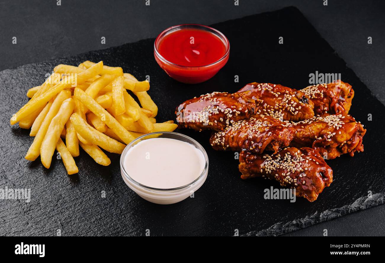 Ali di pollo di bufala calde e piccanti e patatine fritte Foto Stock