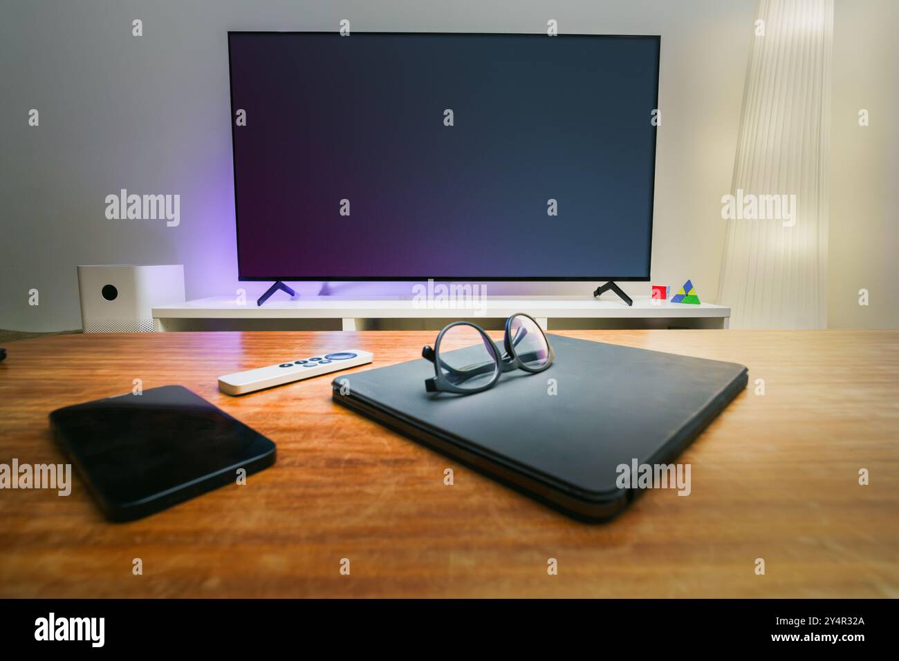 Dispositivi elettronici dello schermo TV sul tavolo. Smartphone tablet portatile grafico sul tavolo. Interno del soggiorno immobiliare. Foto Stock