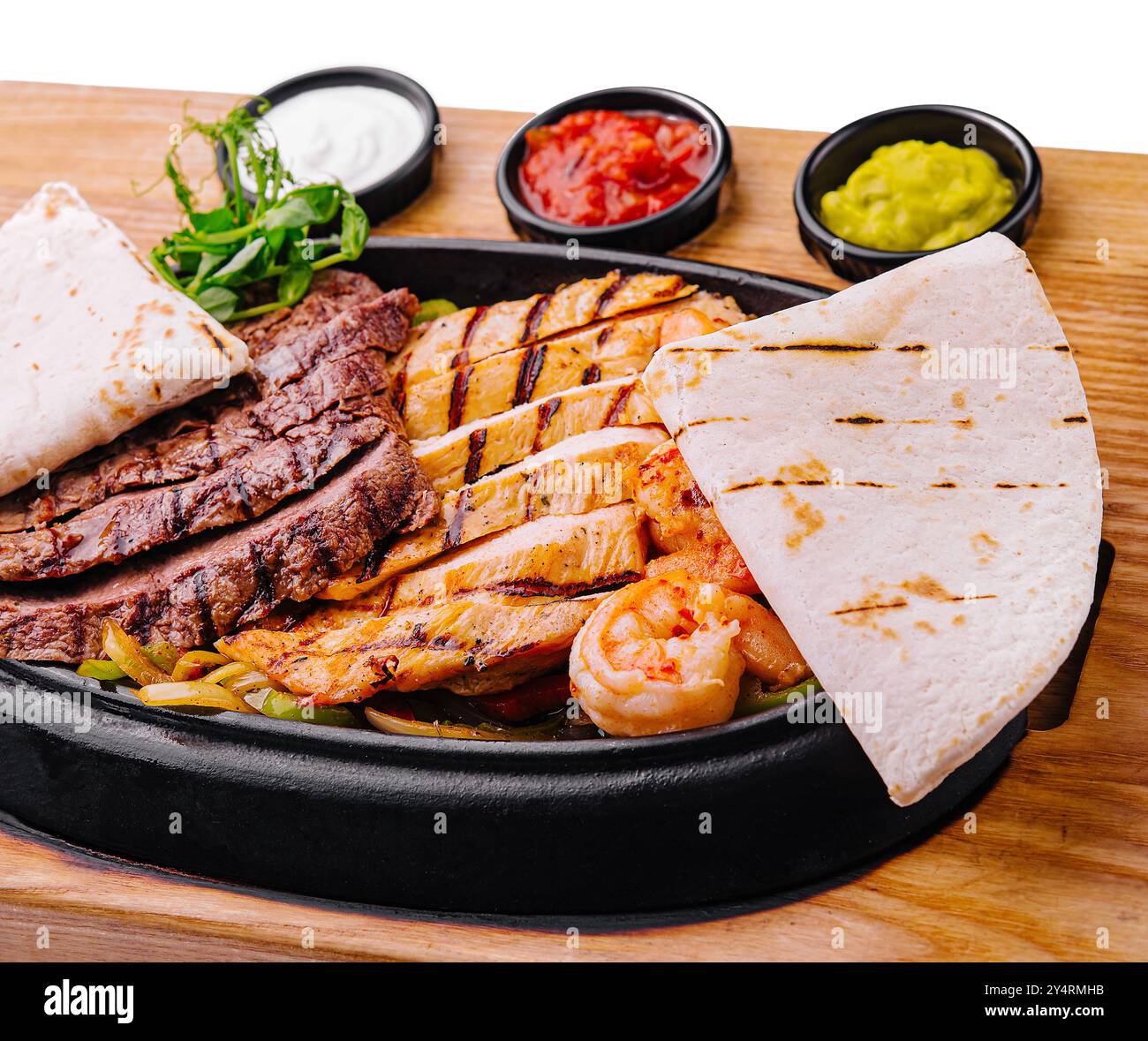 Fajitas di manzo e gamberi su un piatto di ghisa sfrigolante Foto Stock