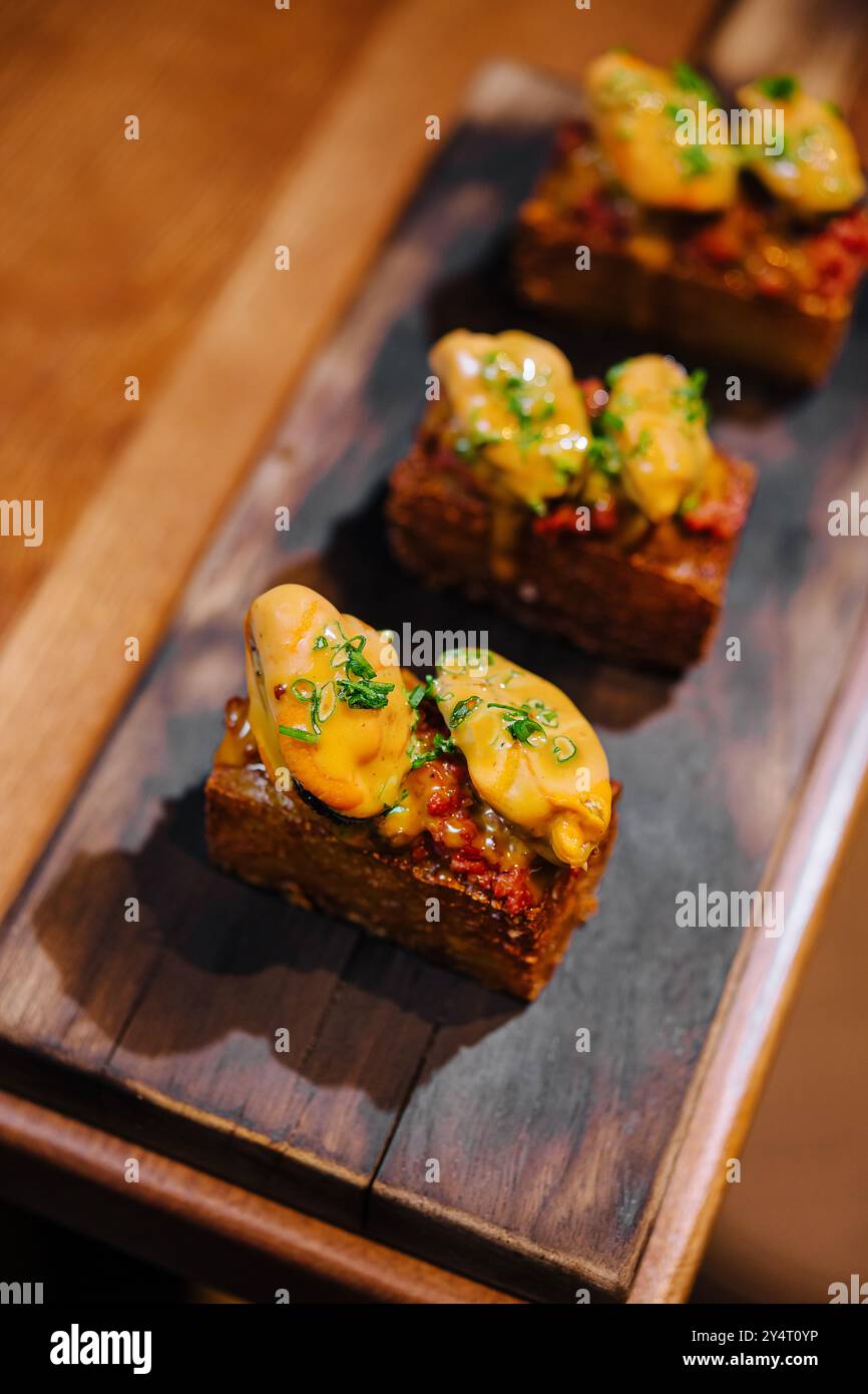 Piccoli spuntini eleganti serviti su una tavola rustica di legno, perfetti per ottimi menu Foto Stock