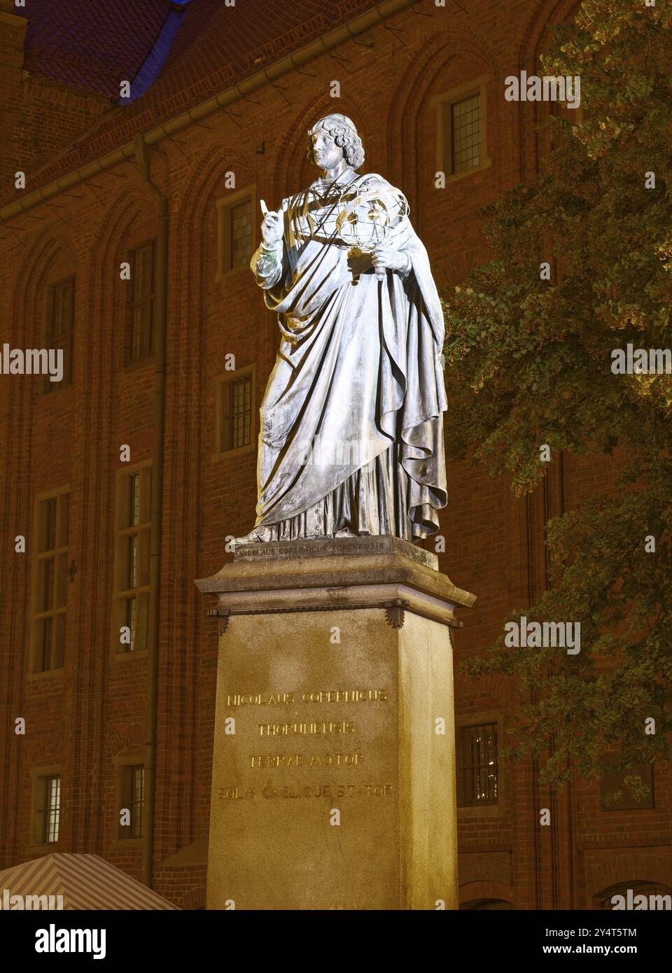 Monumento a Nicolaus Copernico nella città medievale vecchia di Thorn, illuminata di sera. Il centro storico della città di Torun è un'UNESCO World Her Foto Stock