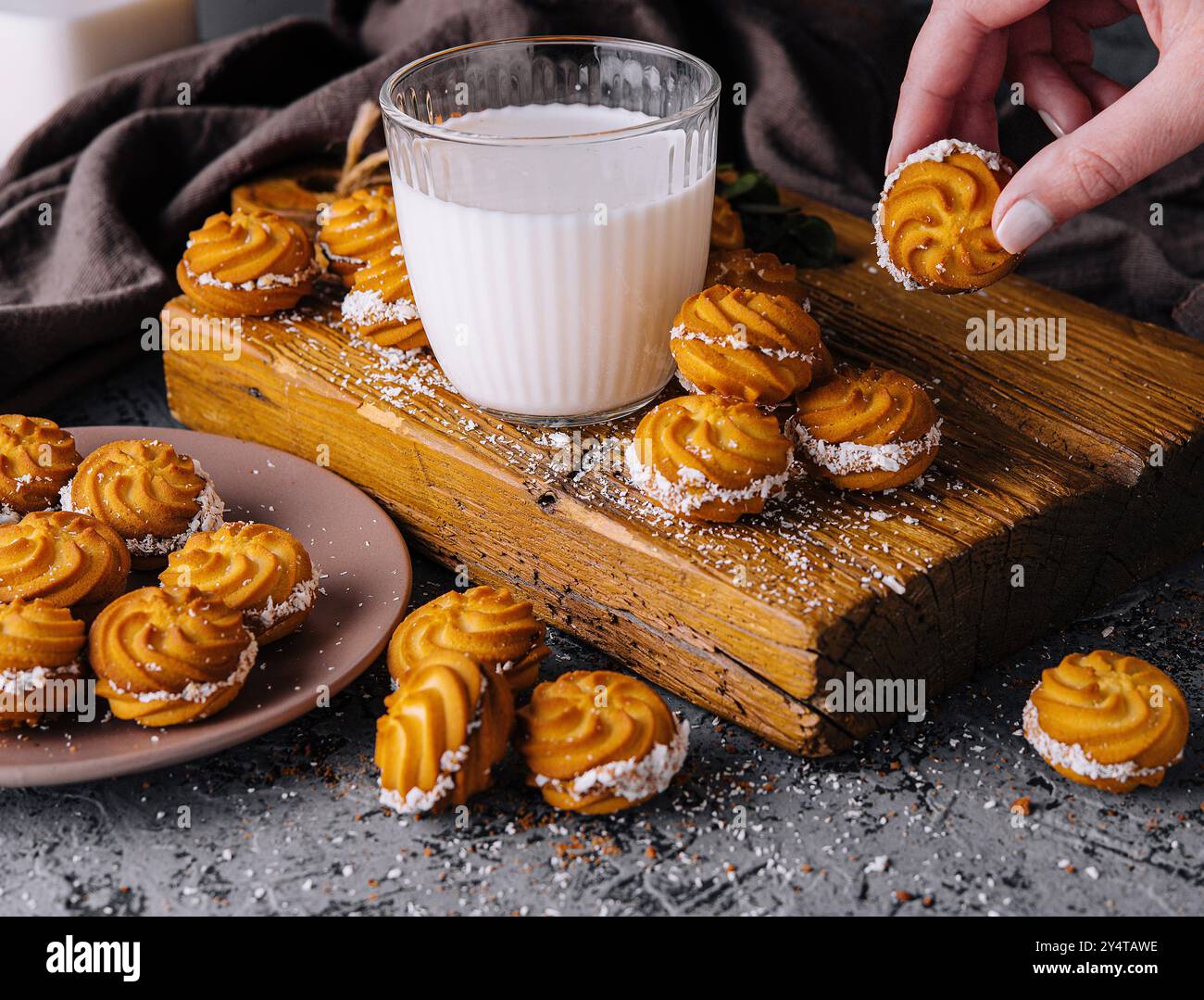 Deliziosi vortici viennesi su una tavola rustica di legno con un bicchiere di latte Foto Stock