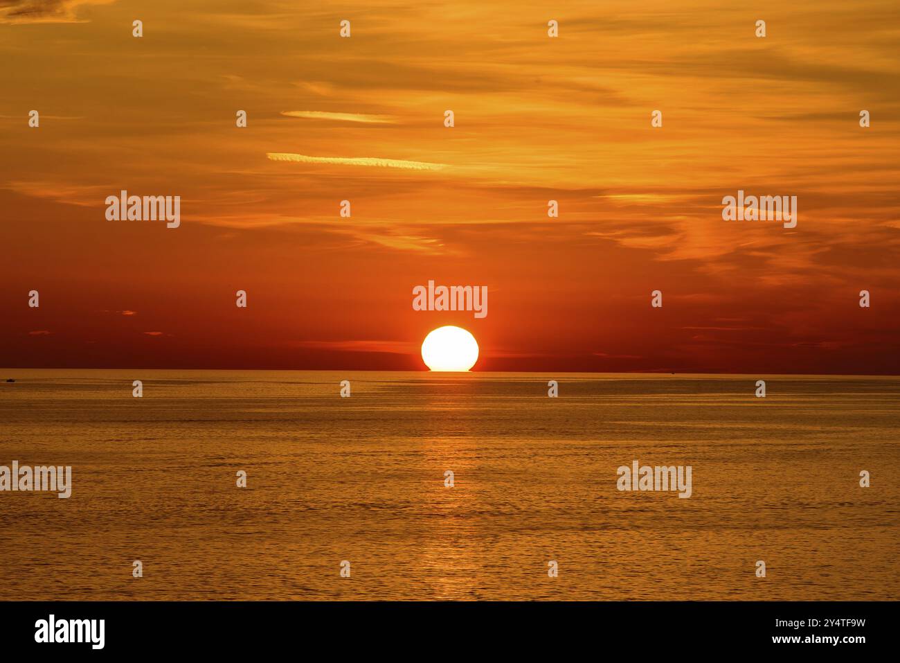 Tramonto sul mare con nuvole arancioni Foto Stock