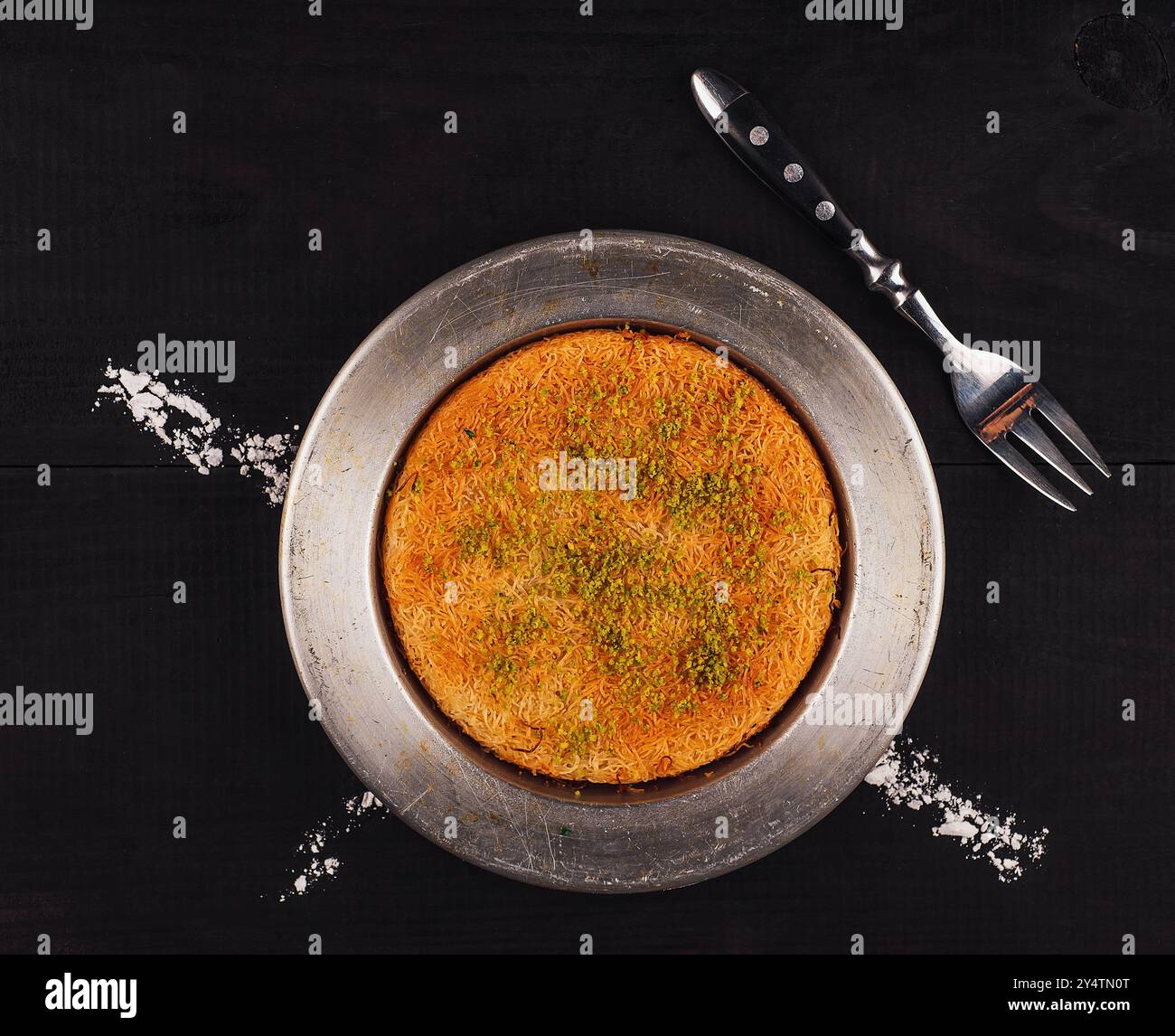 Il Kunefe, noto anche come künefe, è un dolce tradizionale turco a base di pasta fillo grattugiata, formaggio e pistacchi, cotto e impregnato di sciroppo Foto Stock