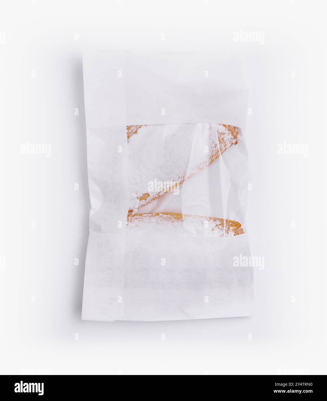 Sacchetto di carta pieno di deliziosi biscotti freschi ricoperti di zucchero in polvere, isolato su sfondo bianco Foto Stock