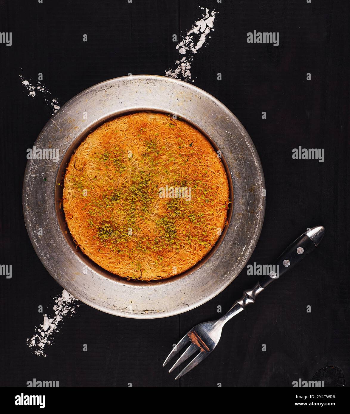 Il Kunefe, noto anche come kьnefe, è un dolce tradizionale turco a base di pasta fillo grattugiata, formaggio e pistacchi, cotto e impregnato di sciroppo Foto Stock