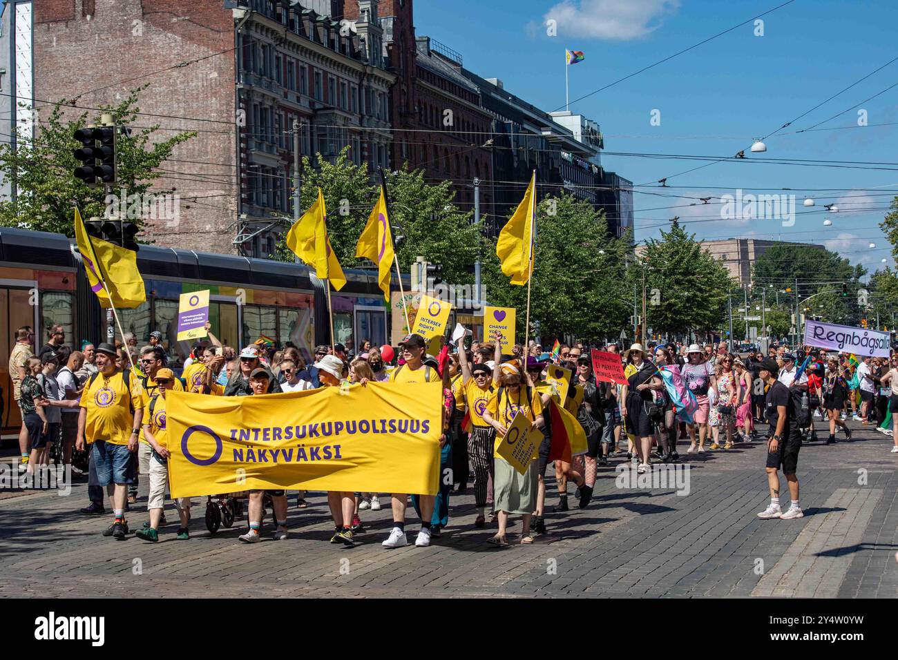 Persone con striscioni, cartelli e bandiere che marciano per i diritti intersessuali alla sfilata Helsinki Pride 2024 su Mannerheimintie a Helsinki, Finlandia Foto Stock