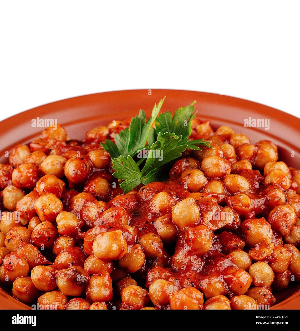 I ceci in salsa di pomodoro con prezzemolo sono serviti su un piatto di argilla come un pasto vegano delizioso e sano Foto Stock