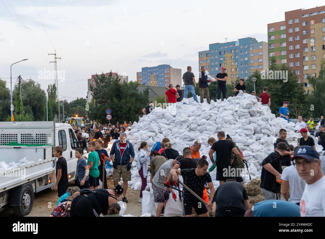 Olawa, Polonia. 18 settembre 2024. Le persone stanno caricando sabbia nei sacchi, mentre altri li stanno spostando ulteriormente per proteggere la città dall'alluvione. Olawa si sta preparando per un'ondata di inondazione sui fiumi causata da forti piogge in questa parte d'Europa. Per diversi giorni, inondazioni potenti e distruttive hanno colpito la Polonia meridionale, devastando interi villaggi e città. In Polonia, 7 persone sono già morte a causa delle inondazioni e i danni sono immensi. Molte persone sono rimaste senza casa, avendo perso i beni della loro vita. In risposta, una mobilitazione a livello nazionale ha avuto luogo Foto Stock