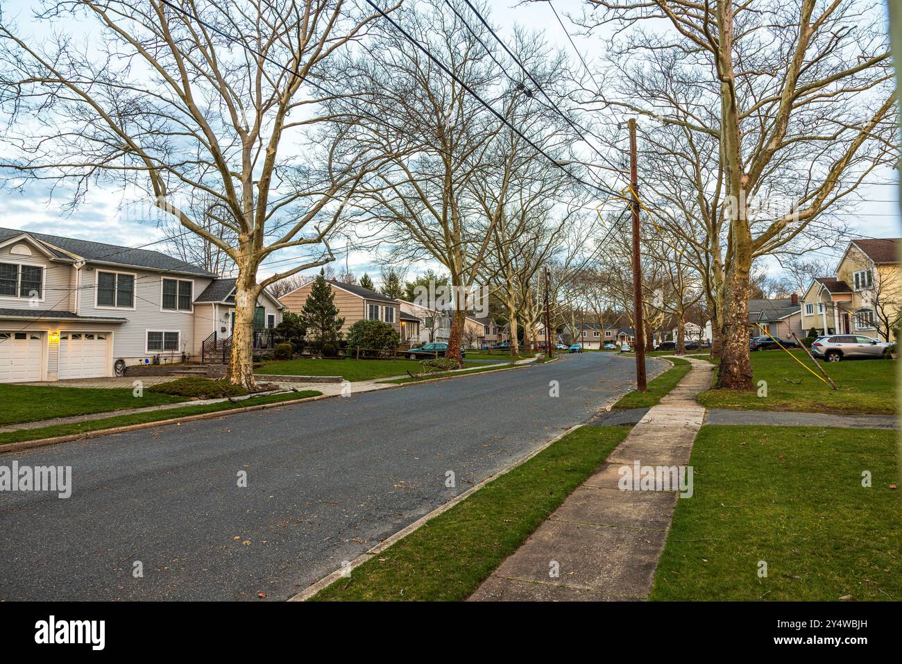 Comunità di ville americane nel New Jersey con prati verdi all'inizio della primavera, strada asfaltata e auto parcheggiate. STATI UNITI. Foto Stock
