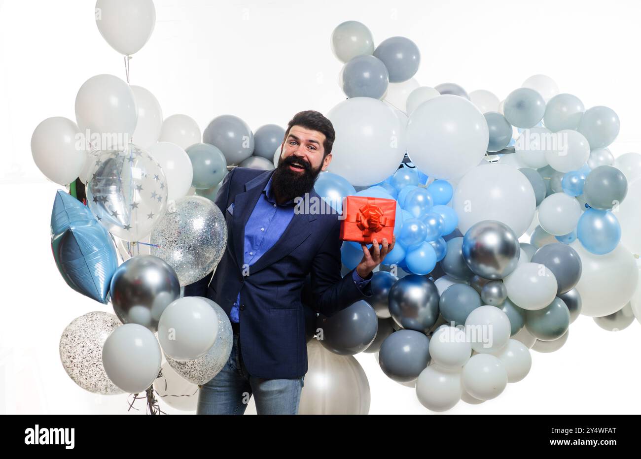 Festa di compleanno. Buon compleanno con palloncini all'elio e confezione regalo. Uomo d'affari sorridente con barba in costume che celebra qualcosa Foto Stock