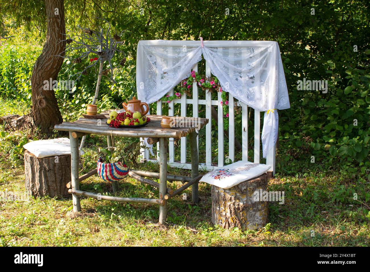 Mobili da giardino per il tempo libero nella natura. Mobili da esterno in legno per picnic nel giardino autunnale. Accogliente cortile interno con tavolo e sedia Foto Stock