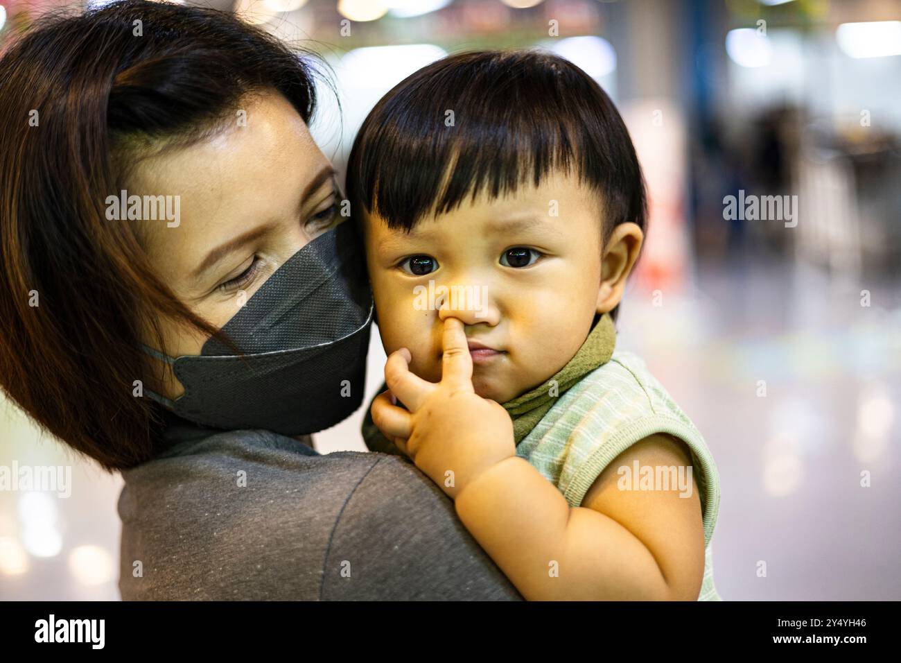 Madre che tiene suo figlio tra le braccia. Foto Stock