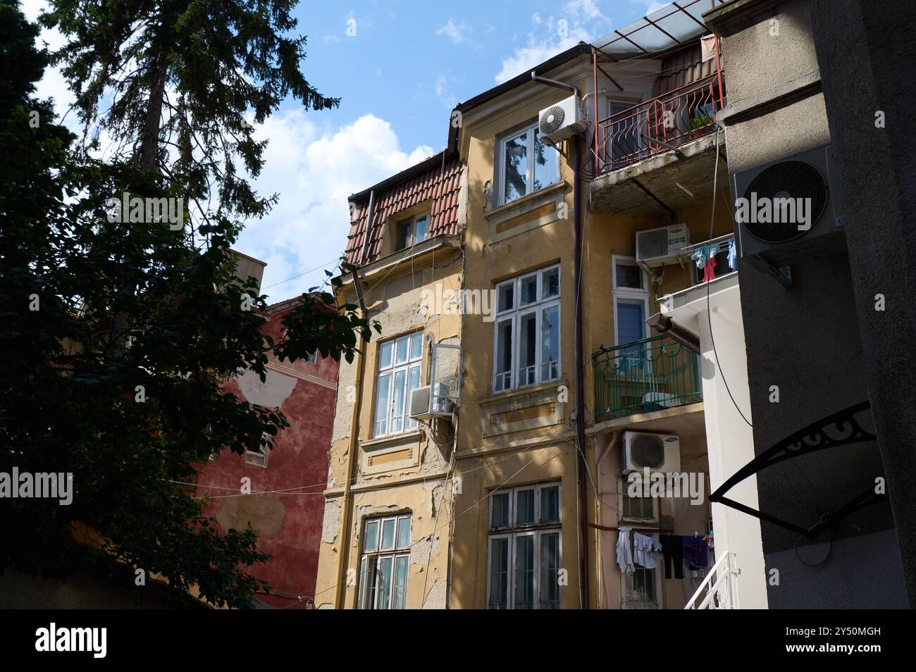 Architettura storica di un pittoresco edificio residenziale in un'area urbana che mette in mostra elementi di design vintage contro un cielo luminoso Foto Stock