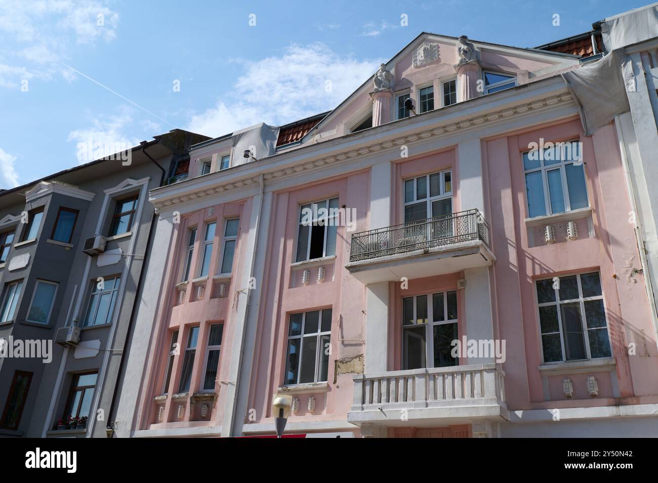 Elegante architettura pastello in un quartiere storico che mette in mostra dettagli intricati sotto un cielo azzurro e limpido nel cuore della città Foto Stock