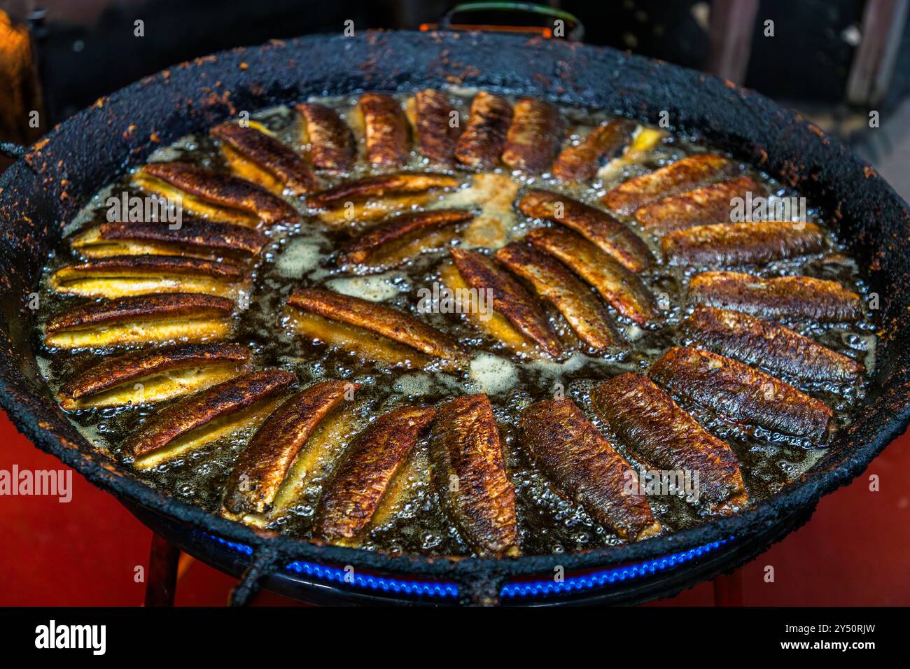 Il fumatore di pesce Föh a Kappeln, un'azienda a gestione familiare dal 1911 i cui tre torrioni sono un punto di riferimento della città, frigge aringhe disposte a cerchio in una grande padella di ghisa. Dehnthof, Schleswig-Holstein, Germania. Foto Stock