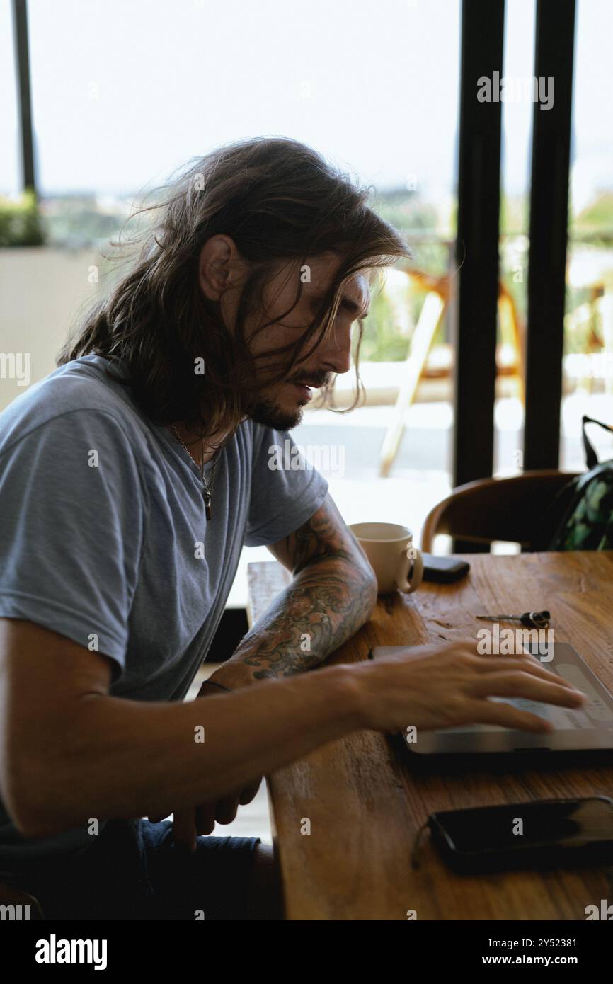 Uomo che utilizza un tablet mentre lavora in ufficio. Foto Stock