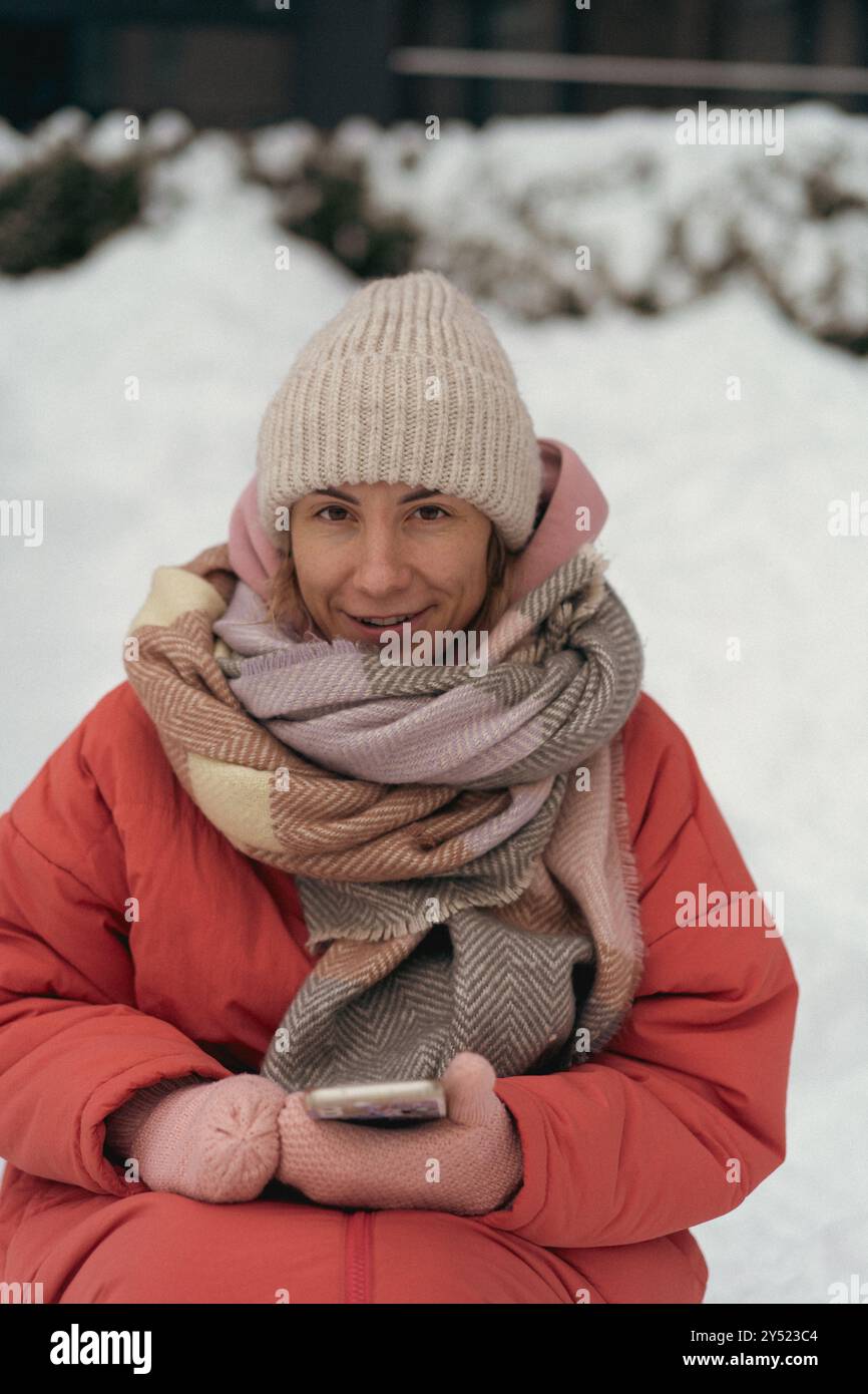 Una donna felice sorride nei boschi innevati in inverno. Foto Stock