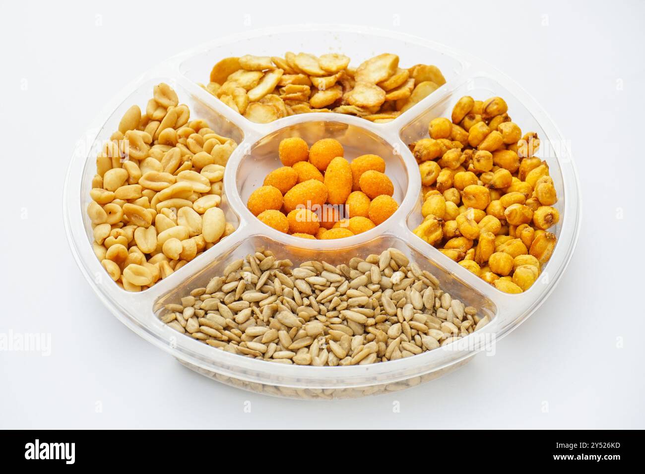 Raccolta di spuntini di sale con frutta secca, semi e mais assortiti per incontri serali con gli amici, vista dall'alto sul piatto isolato su sfondo bianco Foto Stock