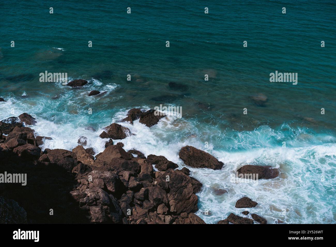 Vista aerea delle onde che si infrangono sulla costa rocciosa Foto Stock