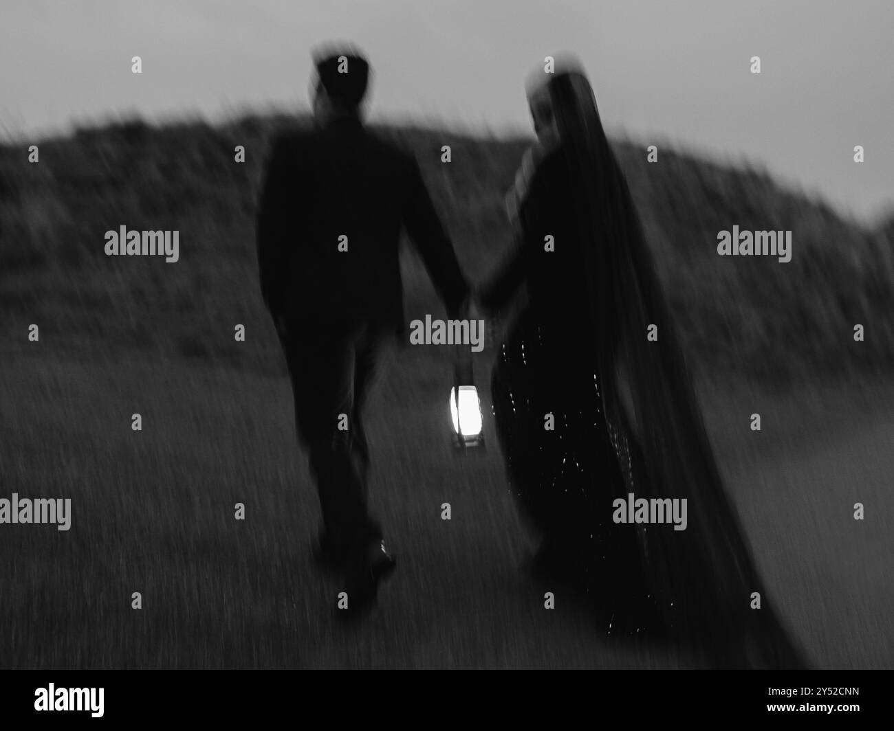 Una coppia spaventosa che cammina con una lanterna di notte a Chambers Bay Foto Stock