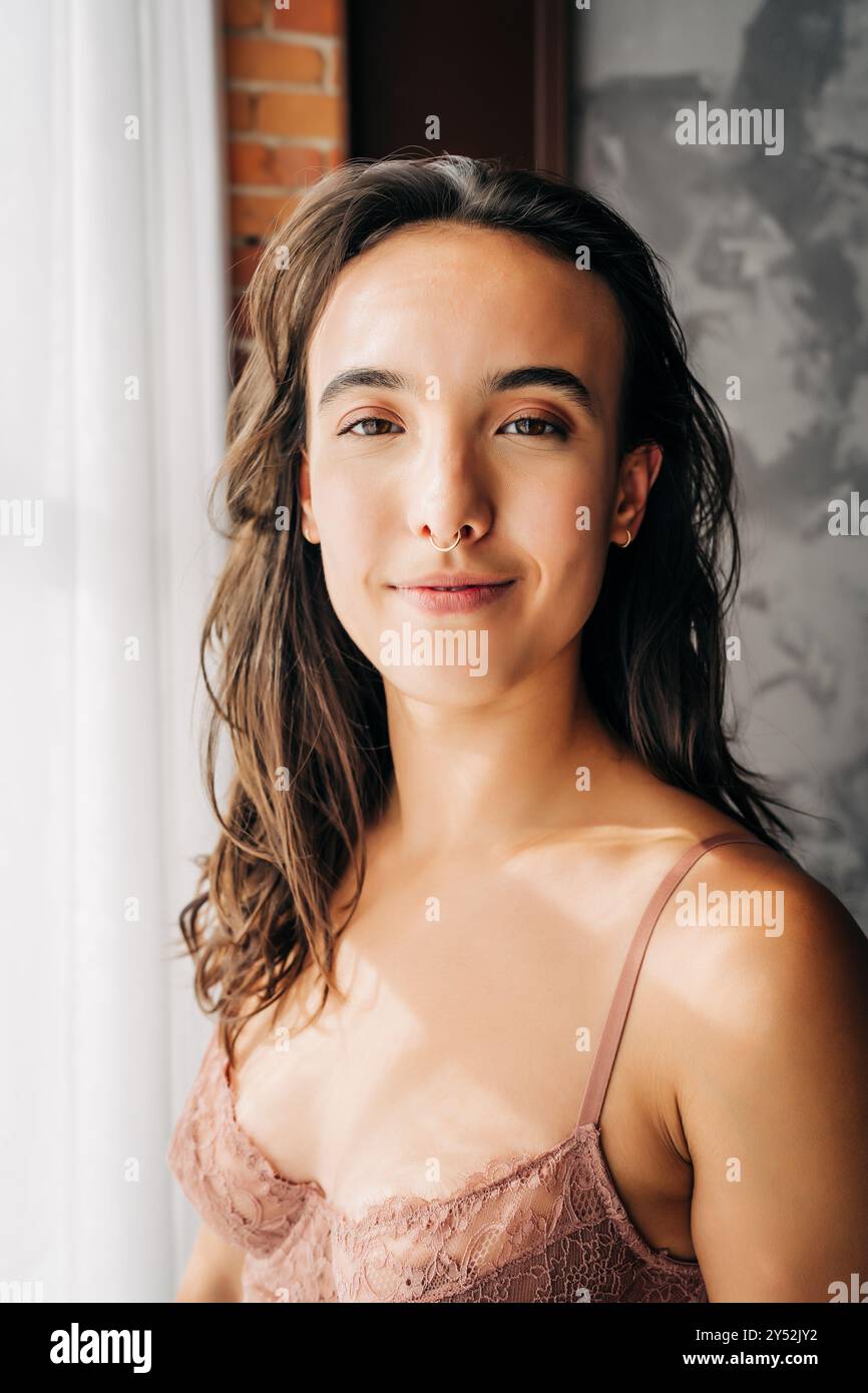 Una donna serena con un'illuminazione soffusa e un'espressione calma e sicura Foto Stock