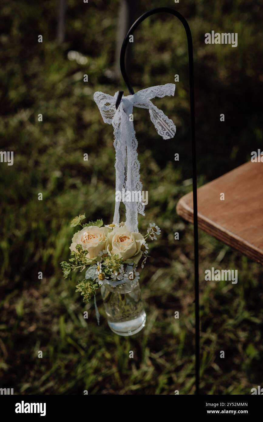 Decorazioni per matrimoni in campagna con rose, nastro in pizzo e camomilla in vaso Foto Stock