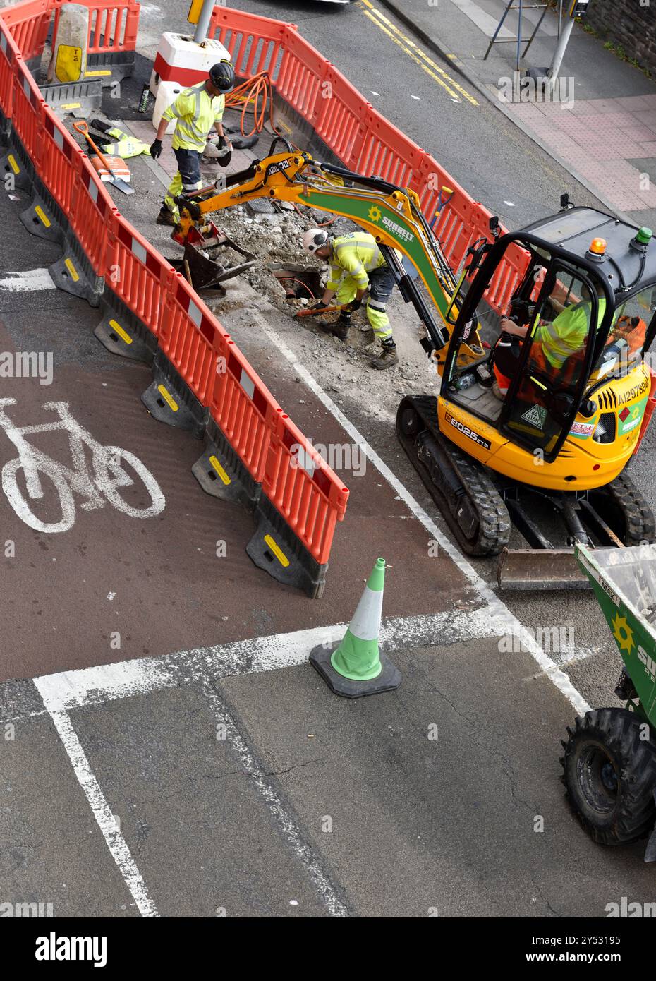 Lavori stradali con scavatore sul centro della città preparativi stradali per il restringimento delle strade e la pista ciclabile, Bristol Foto Stock