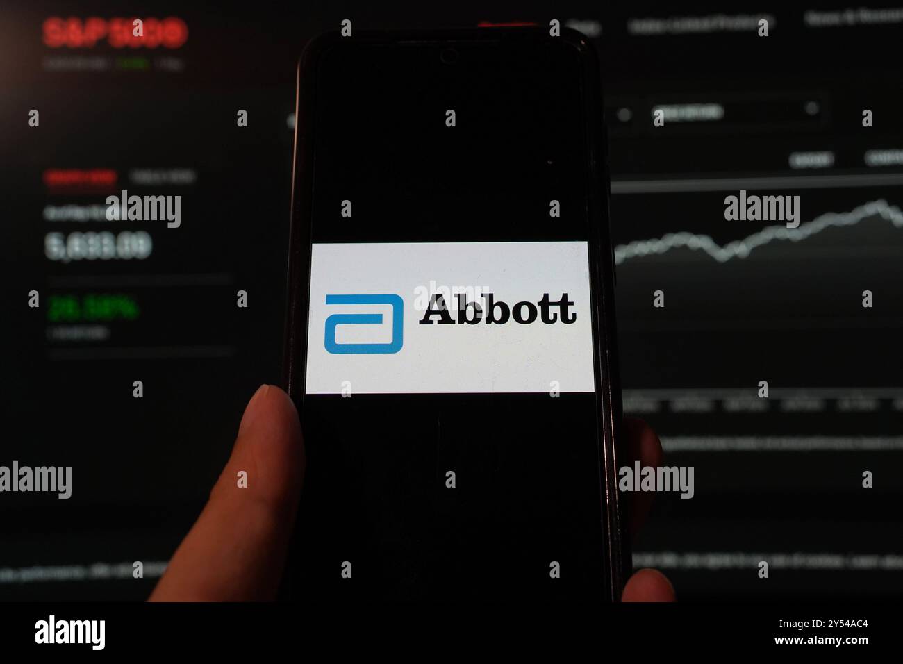 In questa illustrazione fotografica, il logo Abbott Laboratories viene visualizzato su uno smartphone con sfondo del sito Web dell'indice S&P. Foto Stock