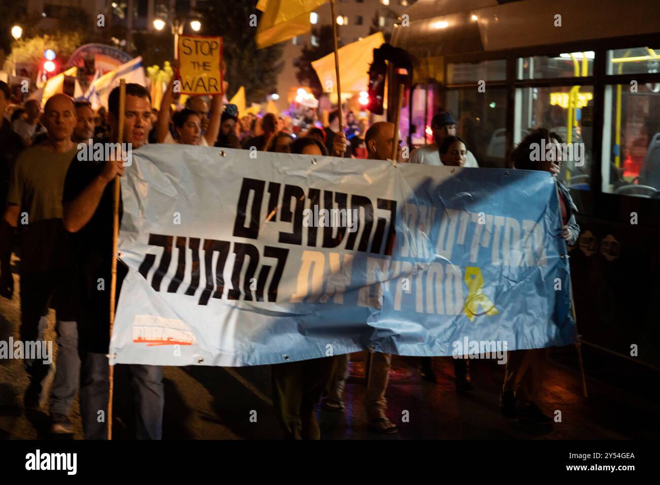 I manifestanti sorpassano un autobus cittadino per le strade di Gerusalemme mentre marciano per il rilascio degli ostaggi e la fine della guerra a Gaza il 14/9/24 Foto Stock