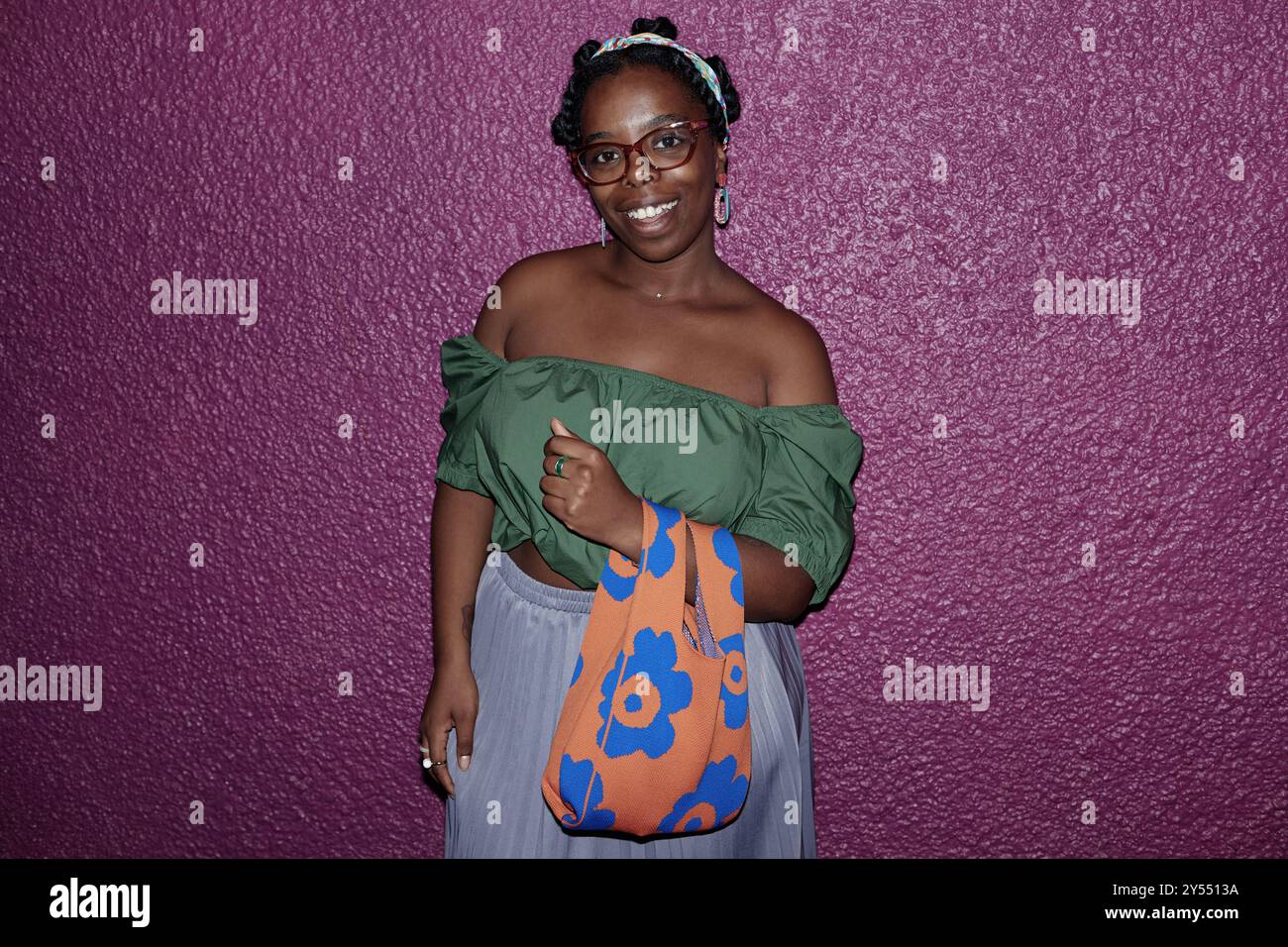 Felice donna afroamericana che guarda la macchina fotografica e sorride mentre posa per una foto Foto Stock