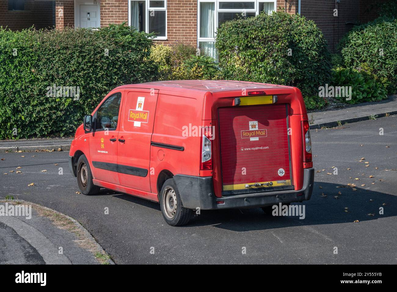 Red mail van in attesa in una strada per il postino di ritorno dopo aver consegnato la posta alle case nell'Hampshire, in Inghilterra Foto Stock