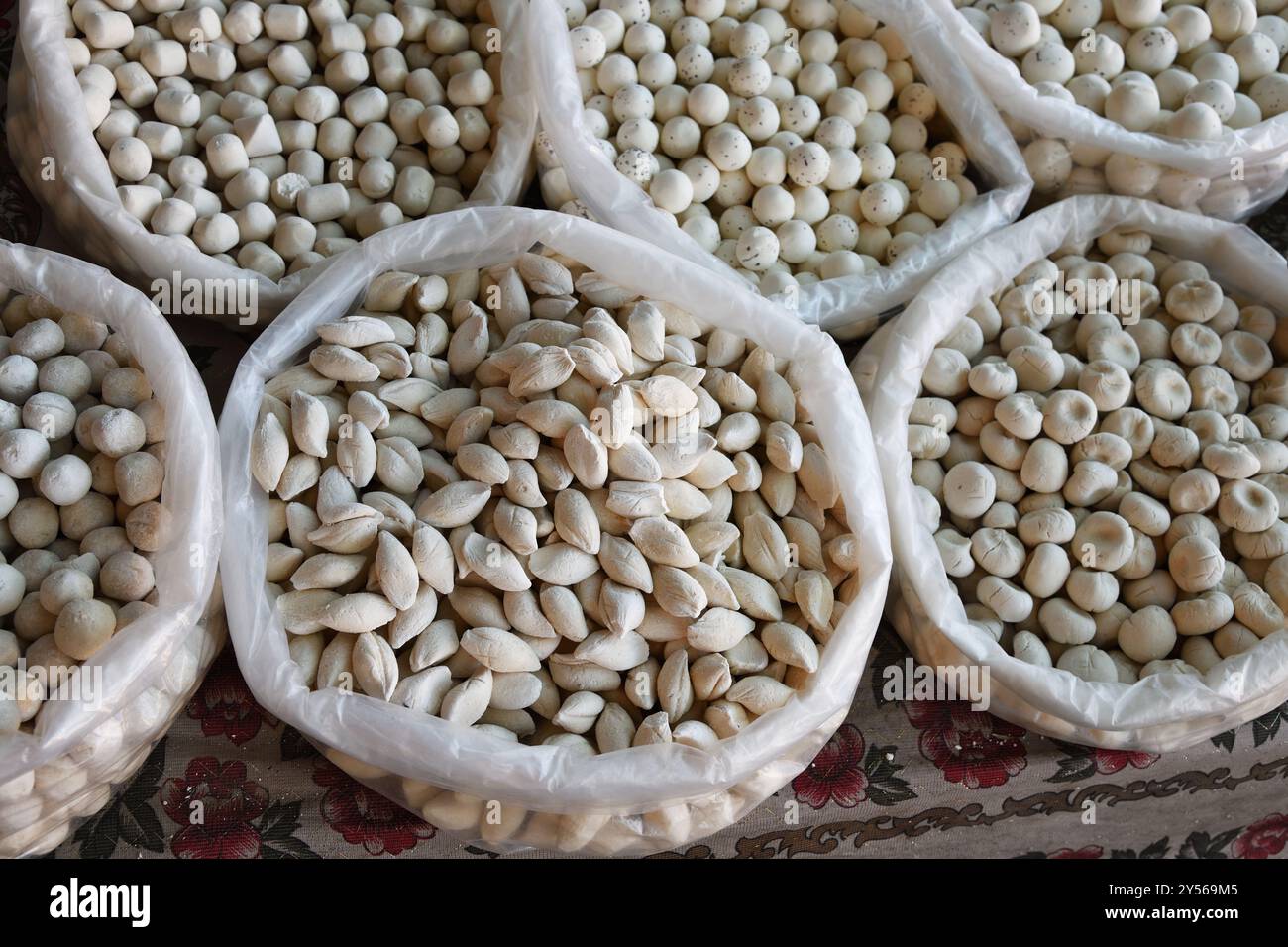 Il formaggio salato Varios, noto anche come qurt o cagliata o kurt in sacchetti, è venduto al bazar uzbeko, in uzbekistan. Cucina nazionale Foto Stock