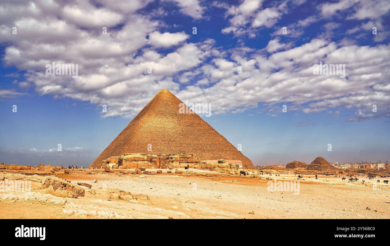 Vista grandangolare della grande Piramide di Khufu, una meraviglia del mondo, e delle sue piramidi satellite in una giornata calda all'altopiano di Giza Foto Stock