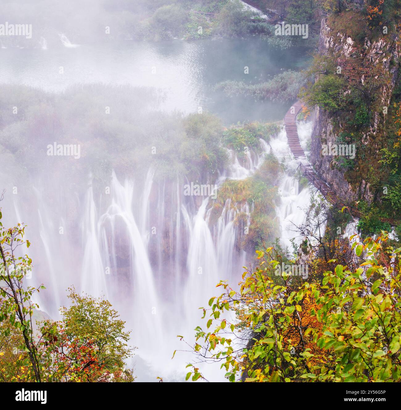 Pittoresca cascata autunnale in un tranquillo ambiente forestale con il clima autunnale piovoso e nebbioso nei laghi di Plitvice Foto Stock