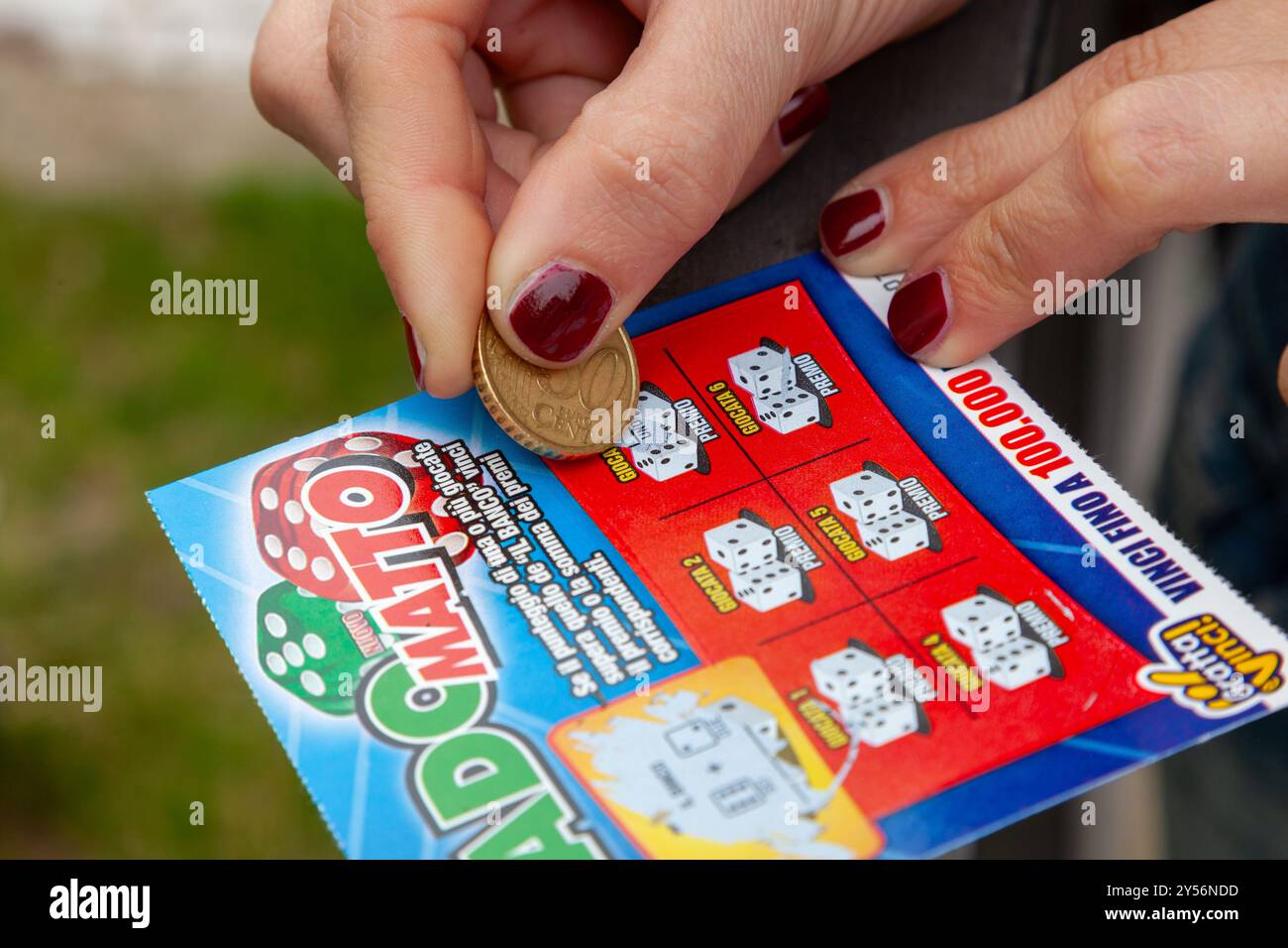 Napoli, Italia - 25 aprile 2011: Dado Matto, gioco del monopolio statale italiano chiamato Gratta e Vinci. La donna gratta il biglietto della lotteria sperando di vincere. Foto Stock