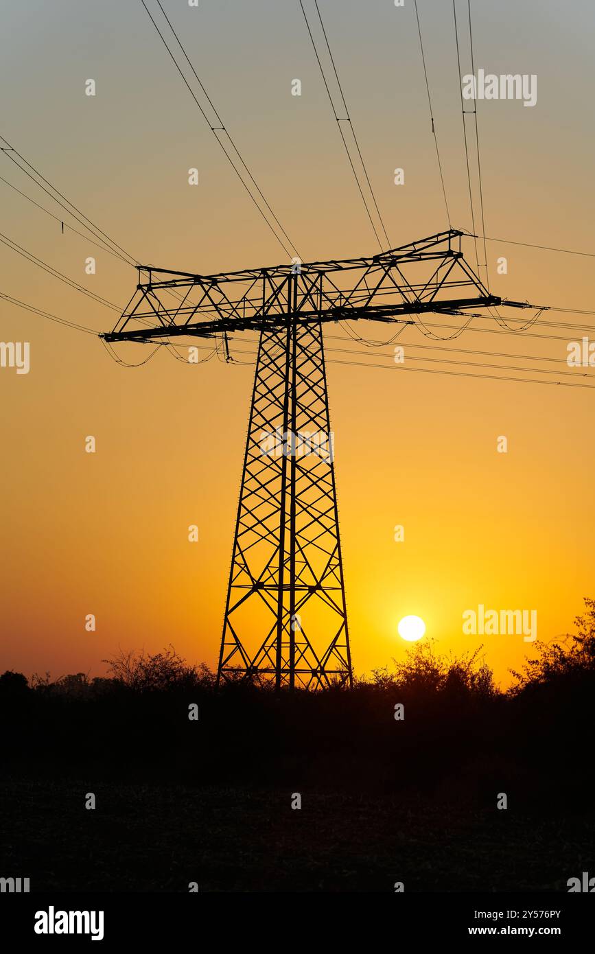 Alba suggestiva su un campo con un'asta di alimentazione la mattina presto in Germania Foto Stock