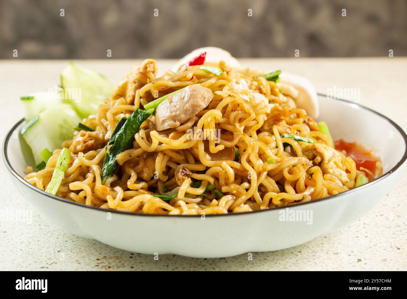 Vista frontale degli spaghetti fritti da vicino con condimento a base di polpette, uova fritte, cibo indonesiano fatto in casa Foto Stock