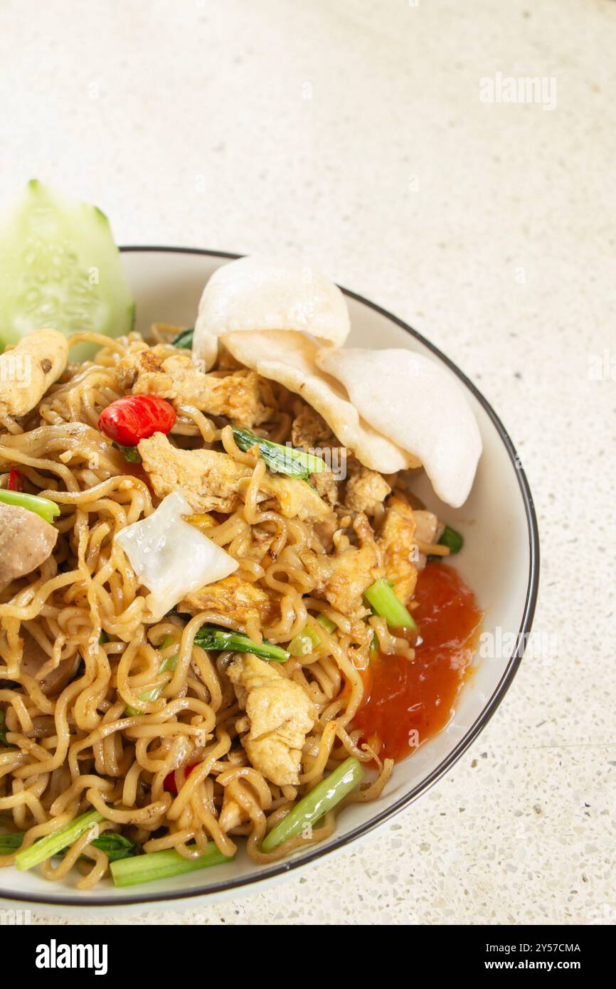 Ritratto fotografico di parti del corpo di pezzi di spaghetti fritti su un piatto su un tavolo di marmo bianco, copia lo spazio sopra Foto Stock