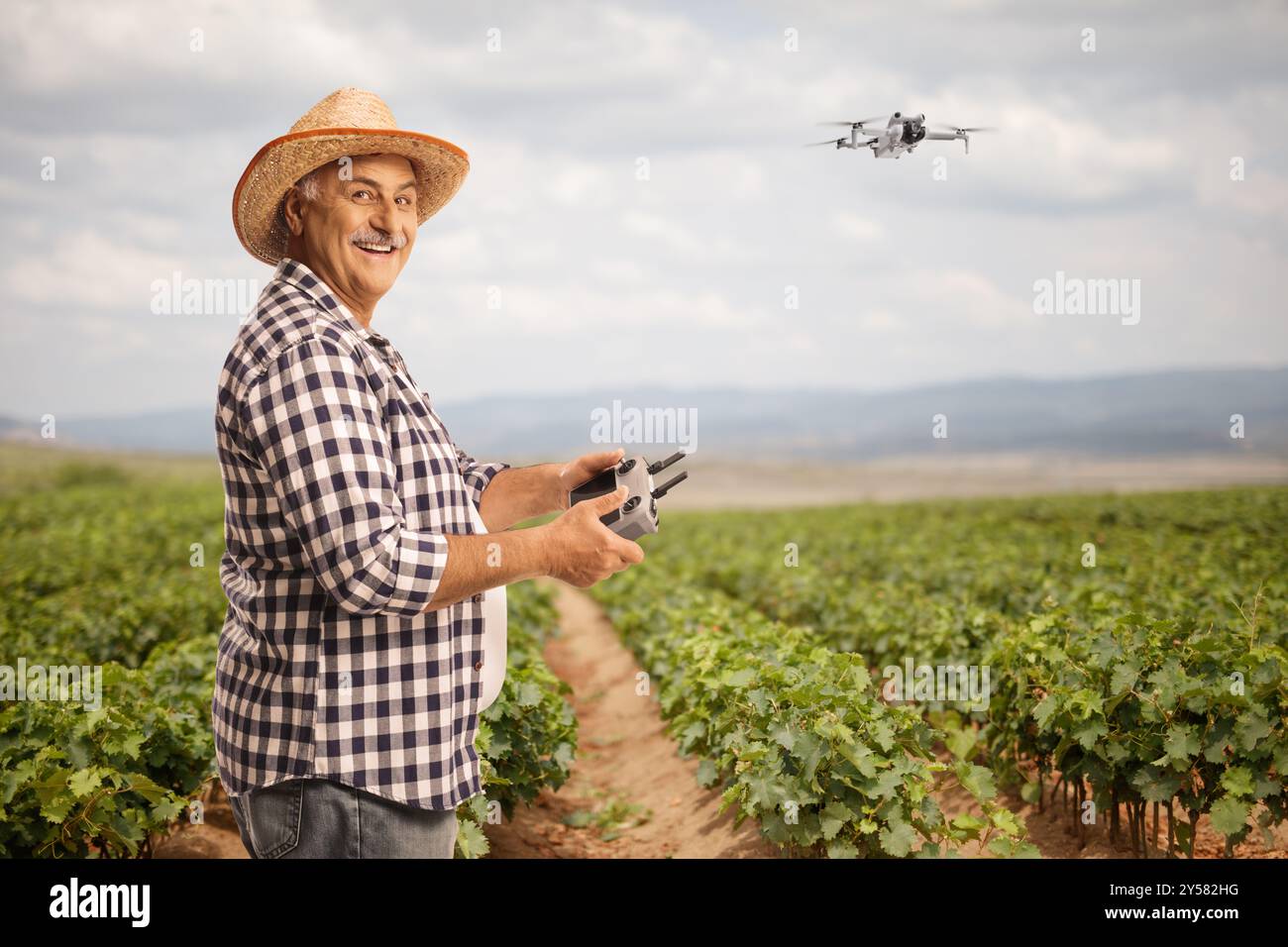 Agricoltore che vola con un drone su un vigneto, agricoltura intelligente e tecnologia avanzata Foto Stock