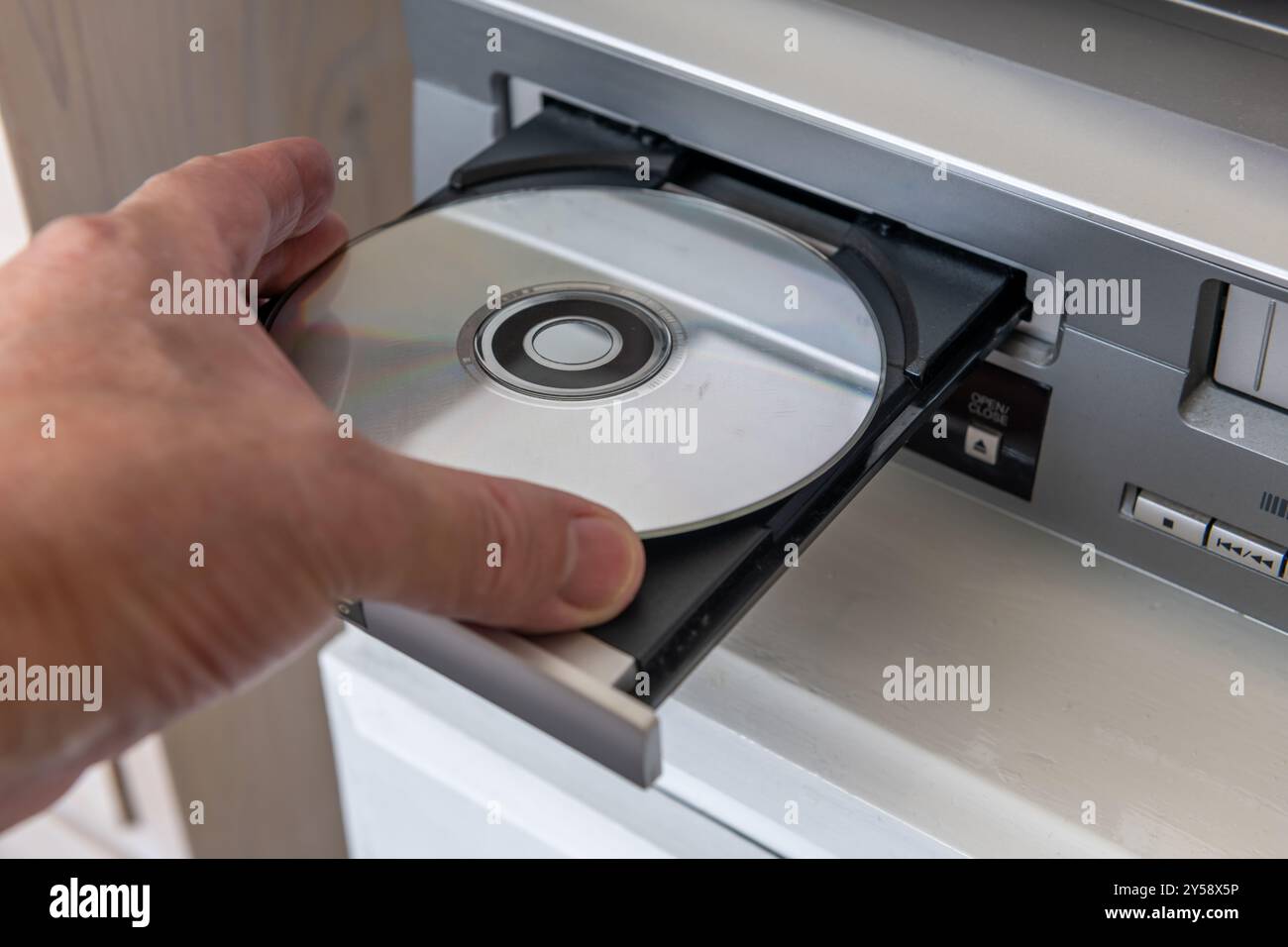 Persona che inserisce un disco video digitale in un lettore DVD. Foto Stock