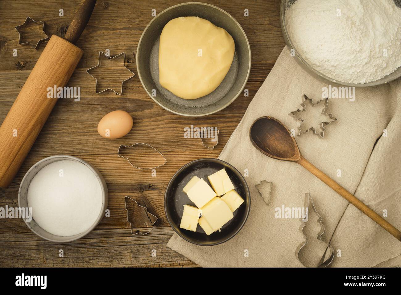 Raccolta di ingredienti e utensili per cuocere i biscotti natalizi su uno sfondo di legno scuro Foto Stock