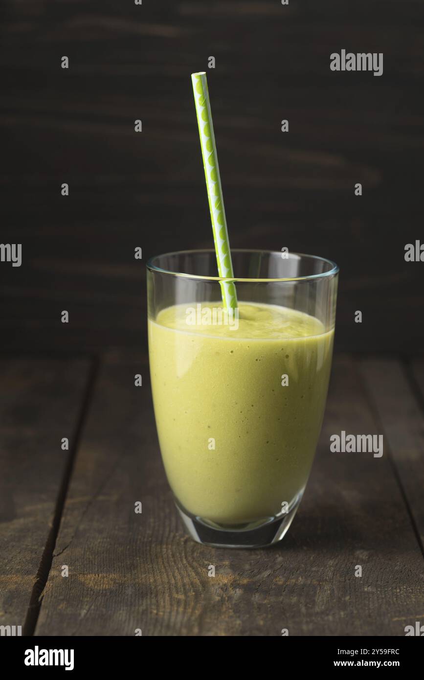 Frullato verde sano con avocado in un bicchiere Foto Stock
