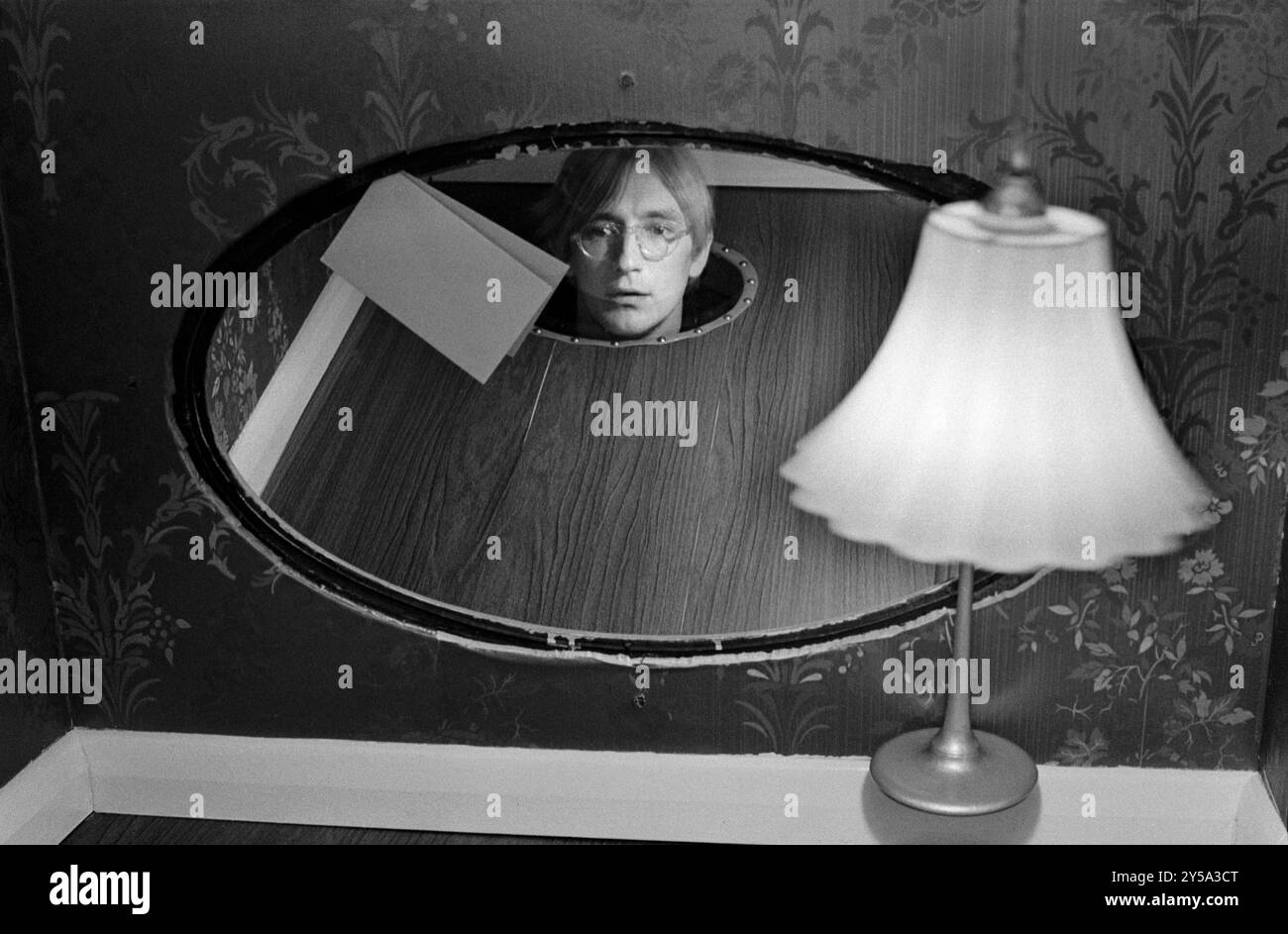 Patrick Hughes artista nel suo studio di Londra, 43 Idmiston Road, London SE27 PH scrive:- sono dentro un lavoro del 1969 realizzato per l'omaggio alla mostra Apollinaire all'ICA nel 1969, il mio pezzo aveva la didascalia: Piega verso il basso e metti la testa su buco nel fondo, e questo è quello che sto facendo, lo specchio era vetro trasparente e sembravi diventare Apollinaire. Inghilterra anni '1968 1960 Regno Unito HOMER SYKES Foto Stock