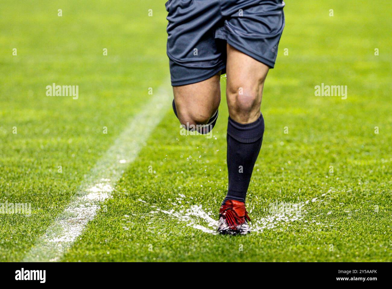 L'arbitro naviga in un campo allagato durante una partita Foto Stock