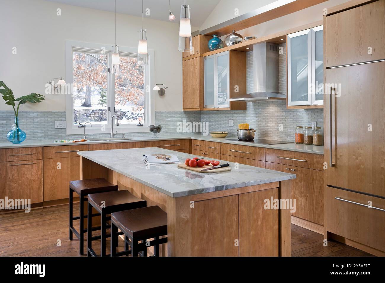 Cucina moderna con caldi armadi in ciliegio e dettagli in acciaio inox Foto Stock