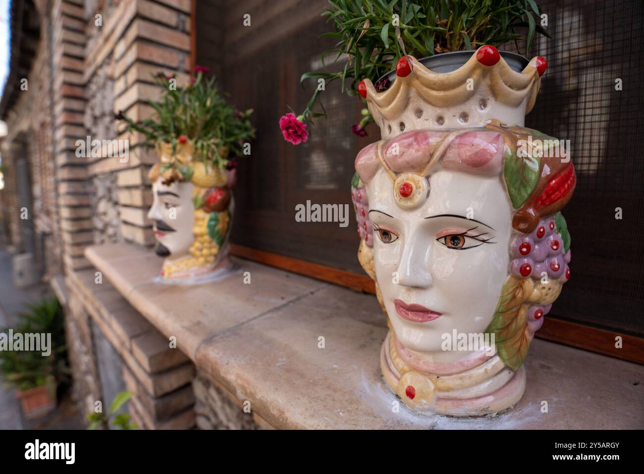 Taormina, Italia - 19 giugno 2024: Teste tradizionali moresche siciliane che decorano la casa. Foto Stock