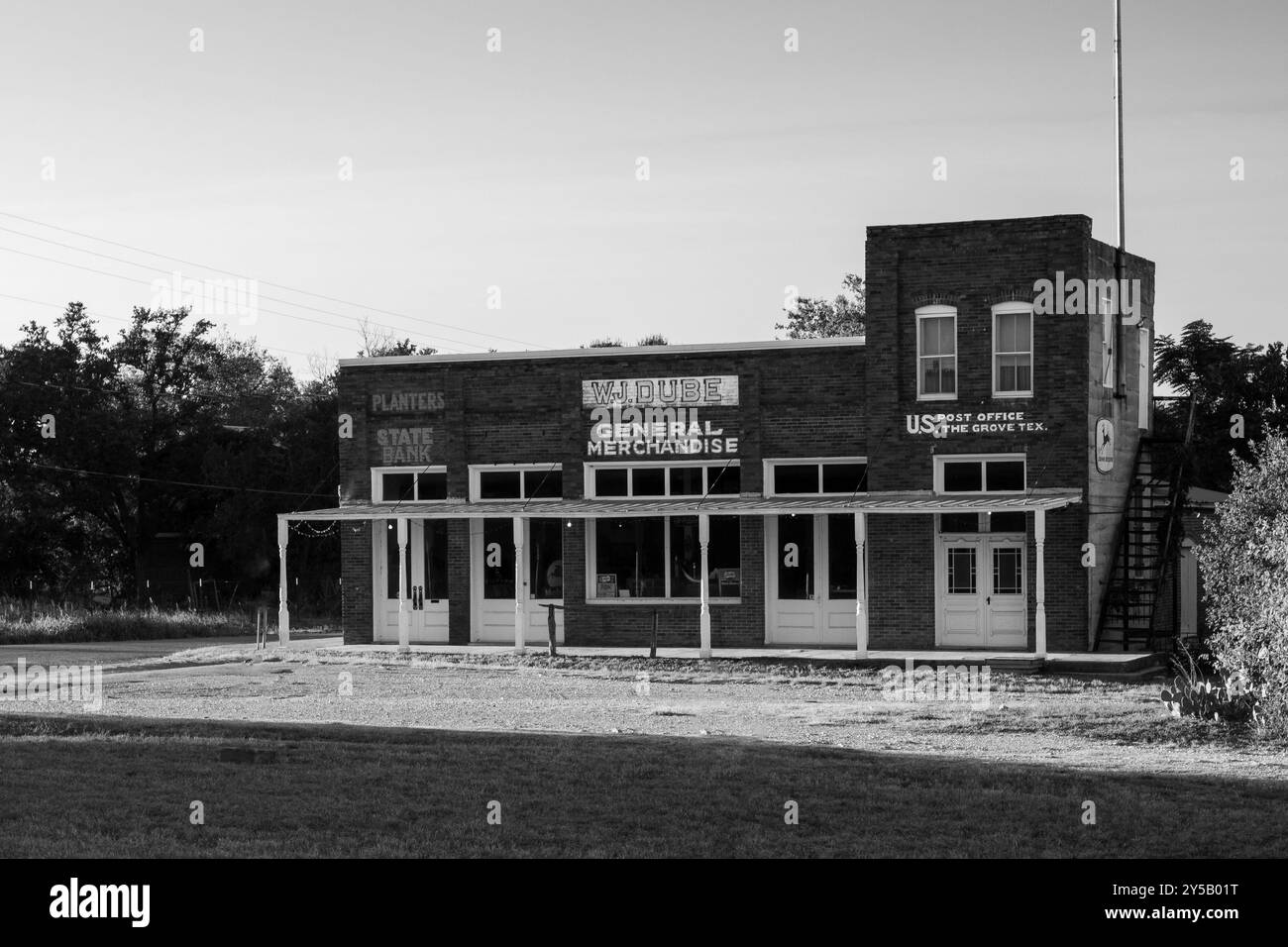 Una fotografia in bianco e nero mostra un negozio storico d'epoca con una banca statale e un ufficio postale su entrambi i lati. In una città fantasma del Texas. Foto Stock