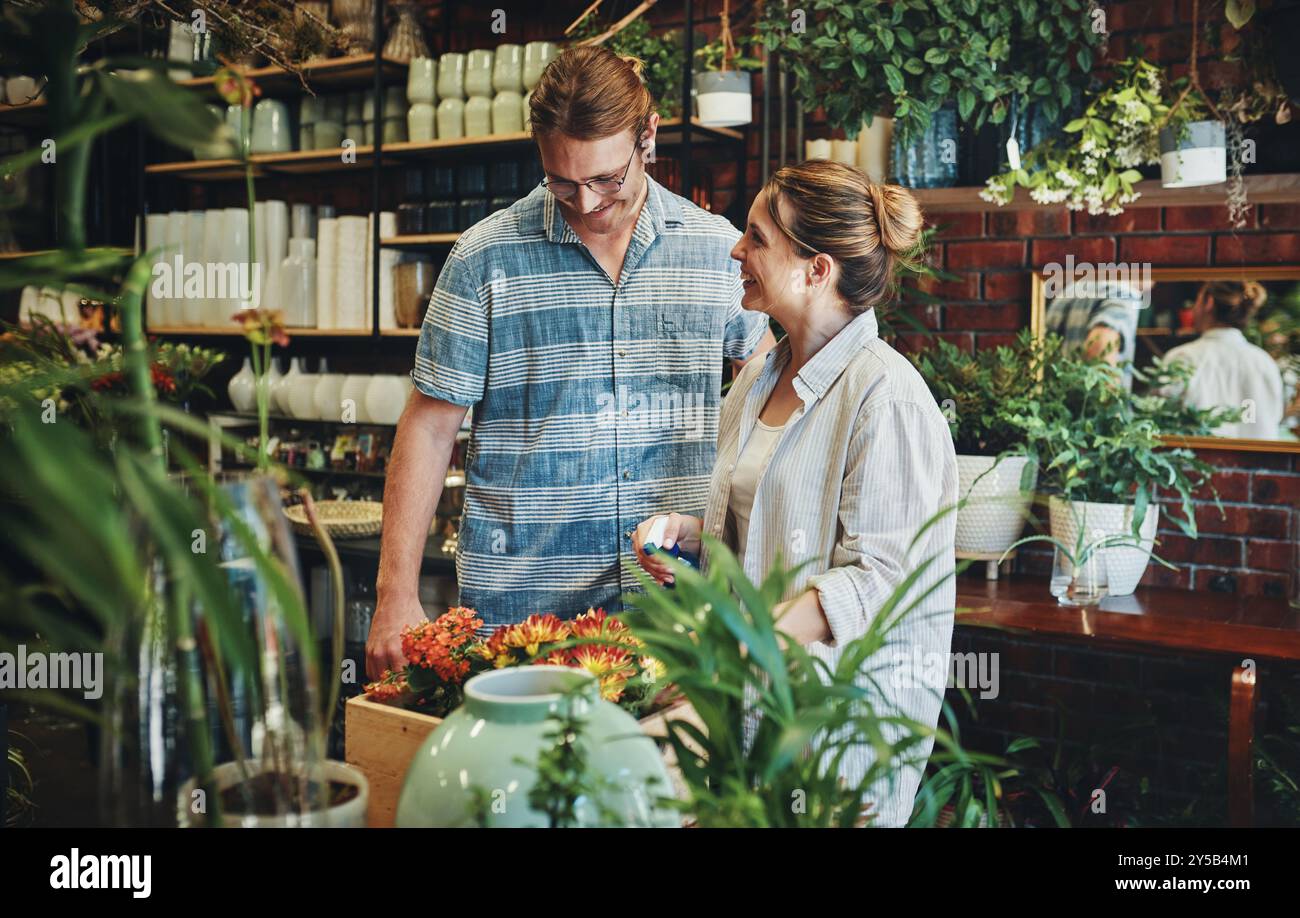 Partner, fiorista e fiori come piante per il giardinaggio, l'arredamento per la casa e piccole imprese nel verde. Donna, uomo e serra in asilo per Foto Stock