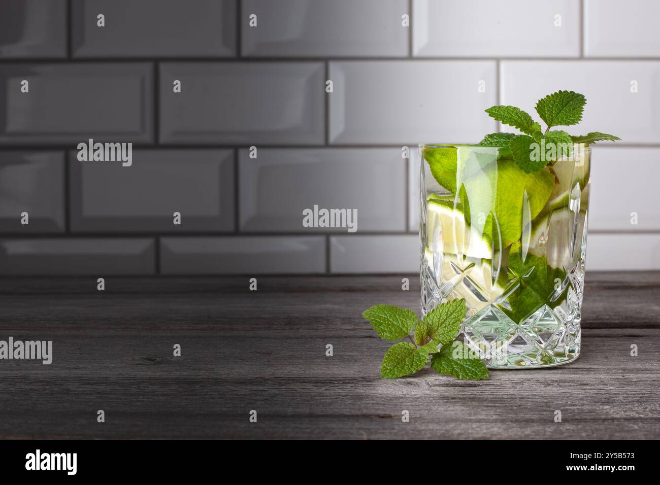 Cocktail Caipirinha originale in piedi sul lato destro dell'immagine. Spazio libero per il testo. Gustoso cocktail con menta, rum, lime, zucchero e ghiaccio. Foto Stock